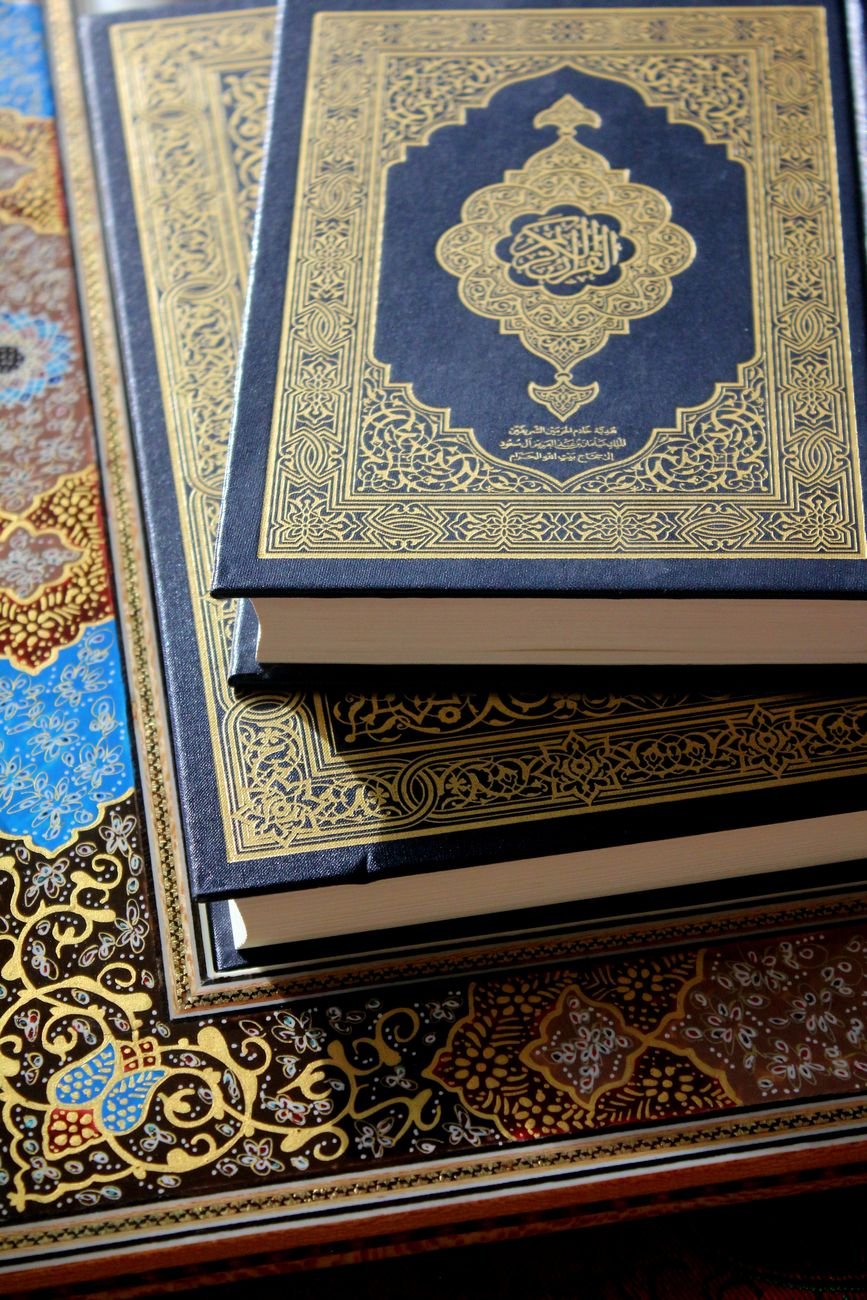 Beautifully adorned religious books with intricate gold and blue illustrated covers
